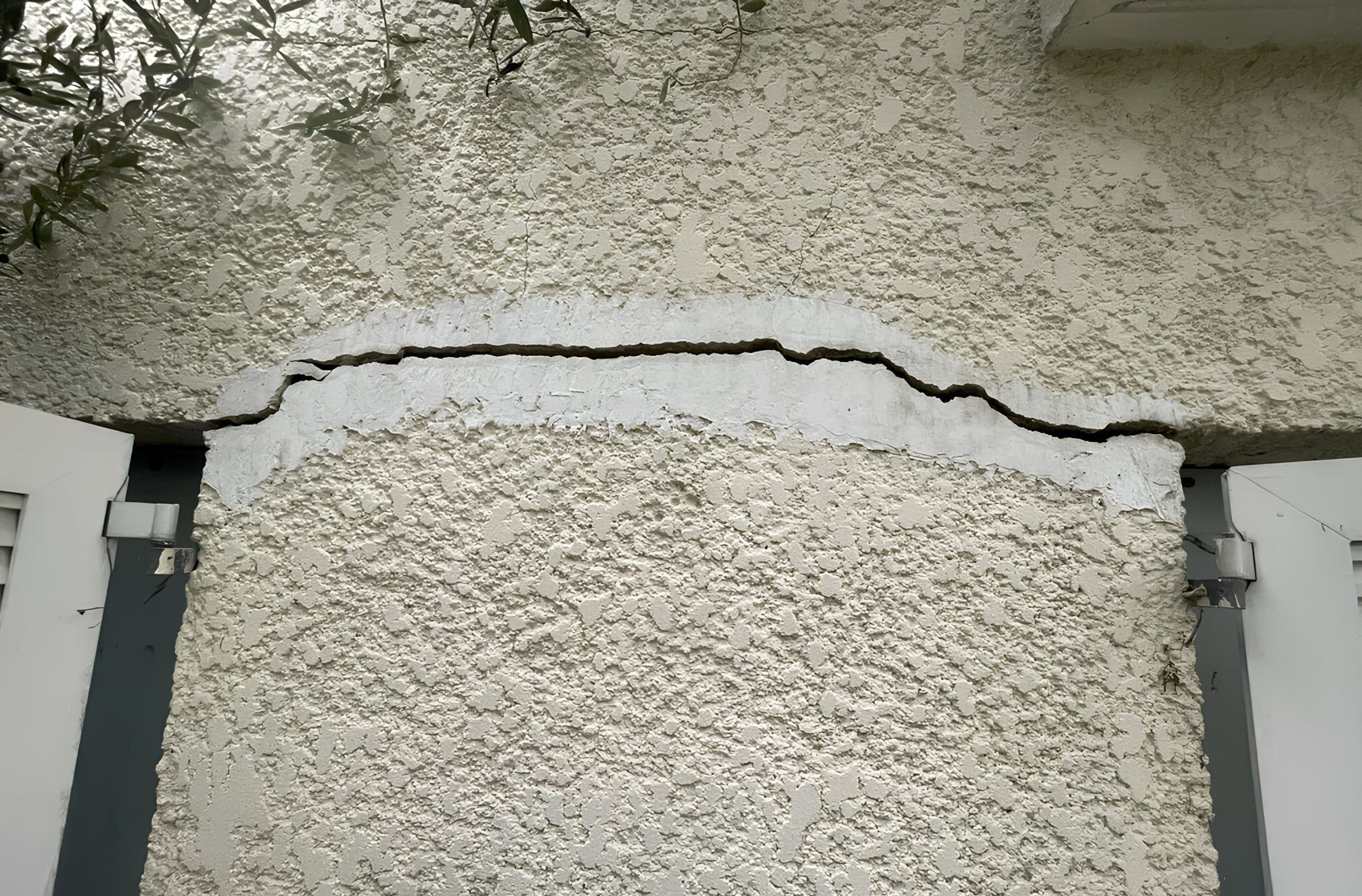On visualise une fissure horizontale sur un mur à l'extérieur d'un bâtiment