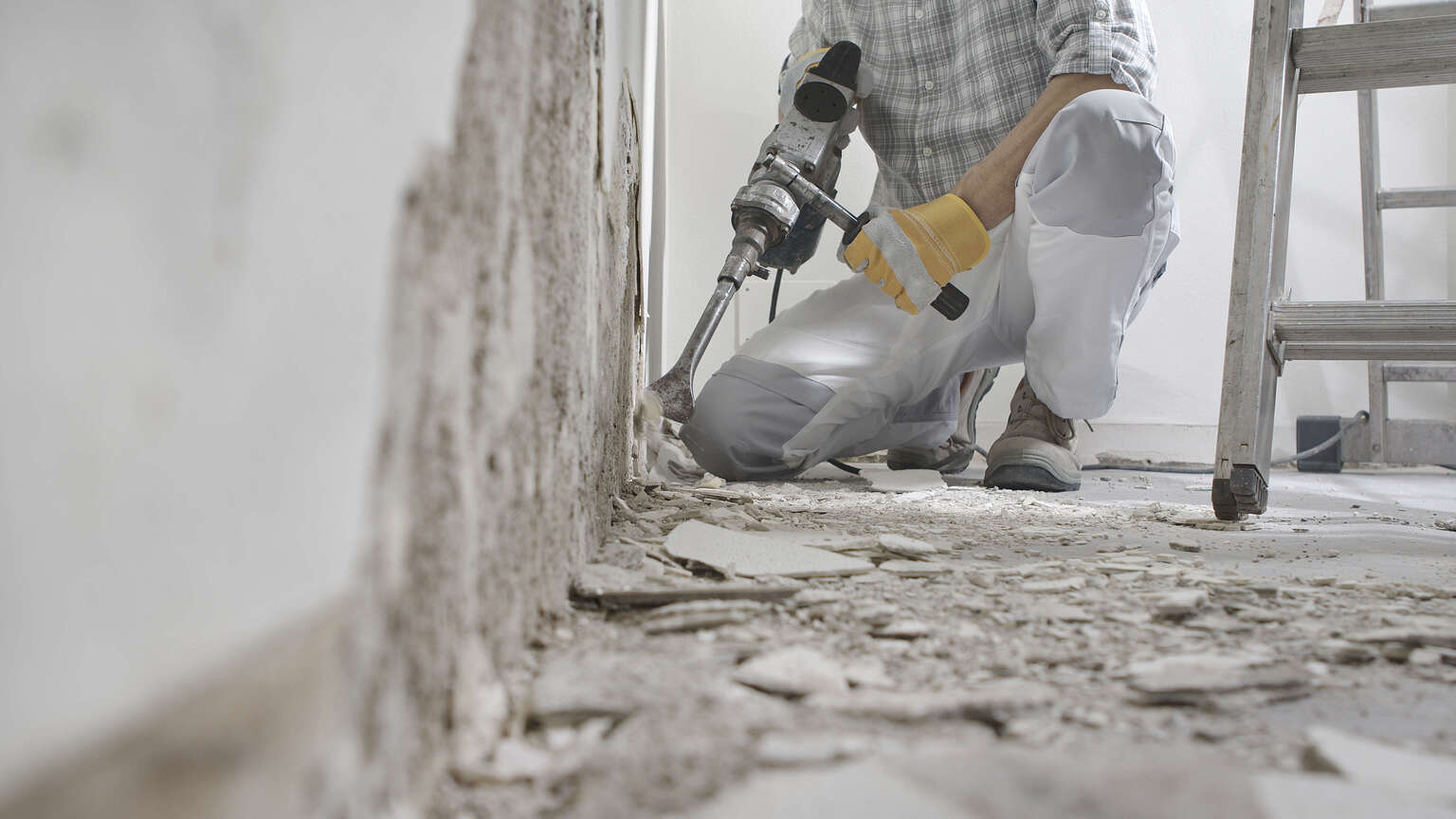 Diagnostiqueur en action avec un perforateur en train de faire un sondage destructif